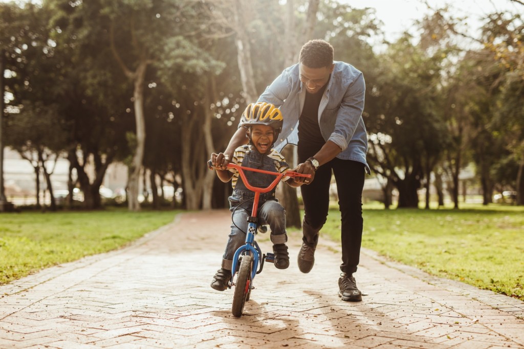 Father teaches his son how to ride a bike without Carpal Tunnel Pain. Carpal Comfort - Designed to Soothe Carpal Tunnel Pain